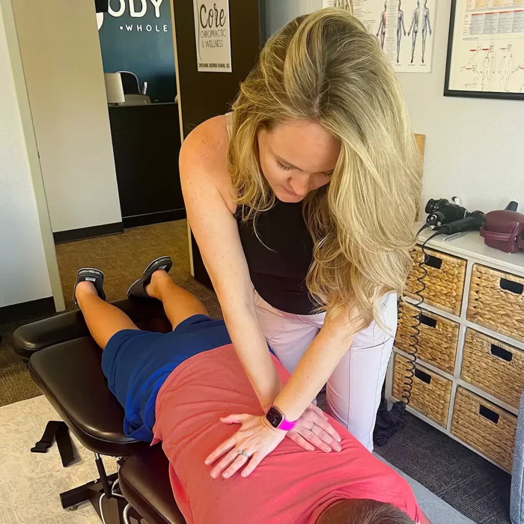 chiropractor adjusting an adolescent's back
